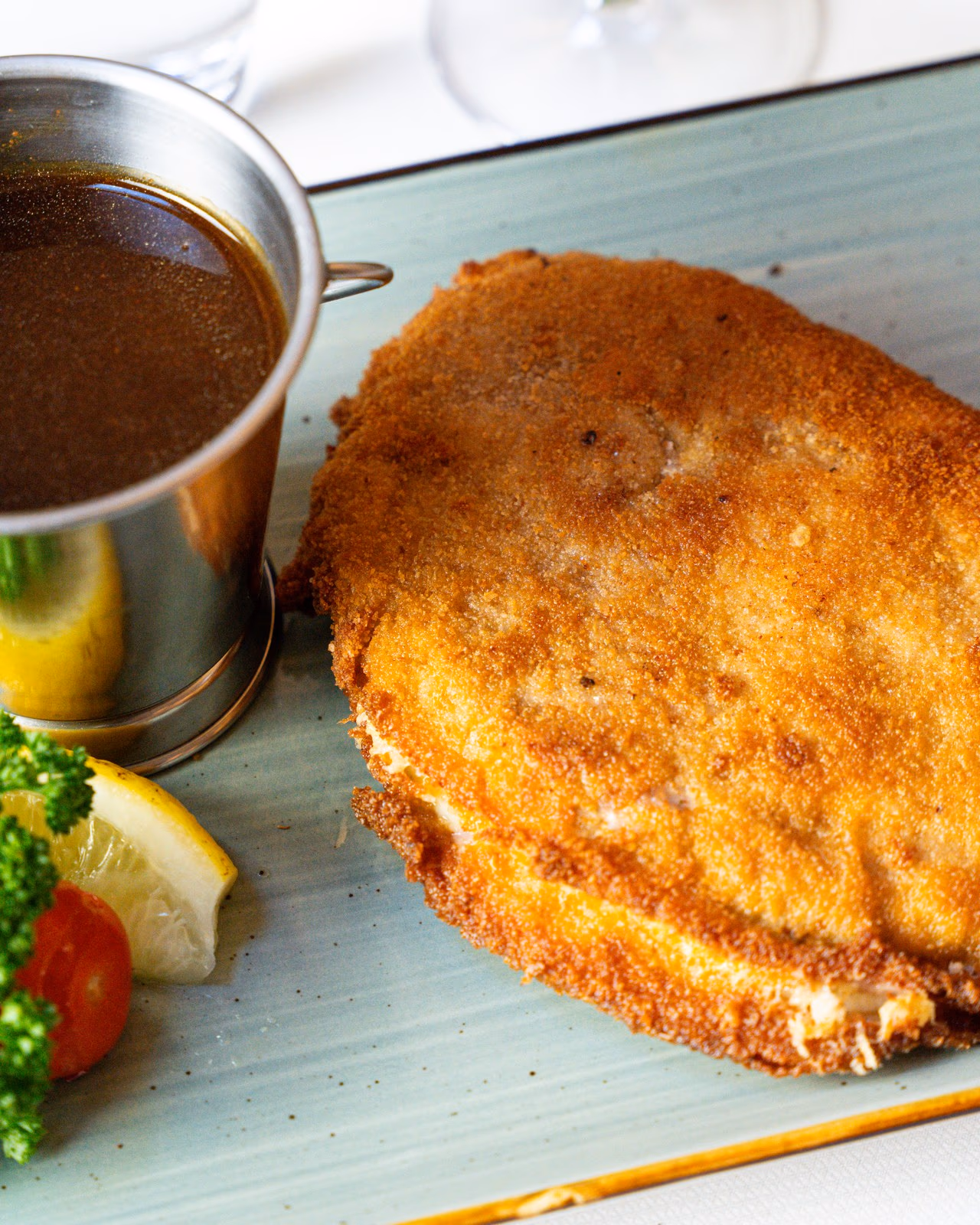 Paniertes Cordon bleu vom Schweinerücken mit Zitrone und Bratenjus