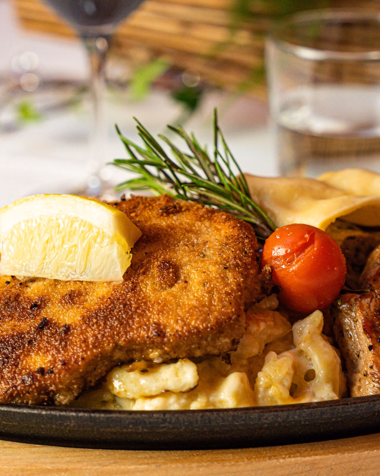 Wirtshauspfanne mit paniertem Schnitzel, Käsespätzle und Maultasche in der Gusspfanne