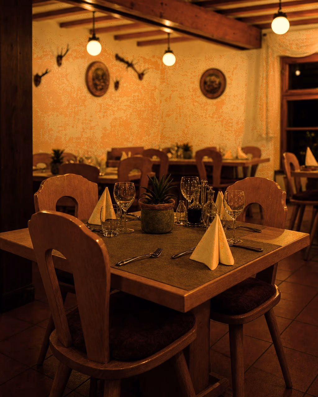 Gedeckter Tisch in der Gaststube mit Holzstühlen und roten Sitzkissen