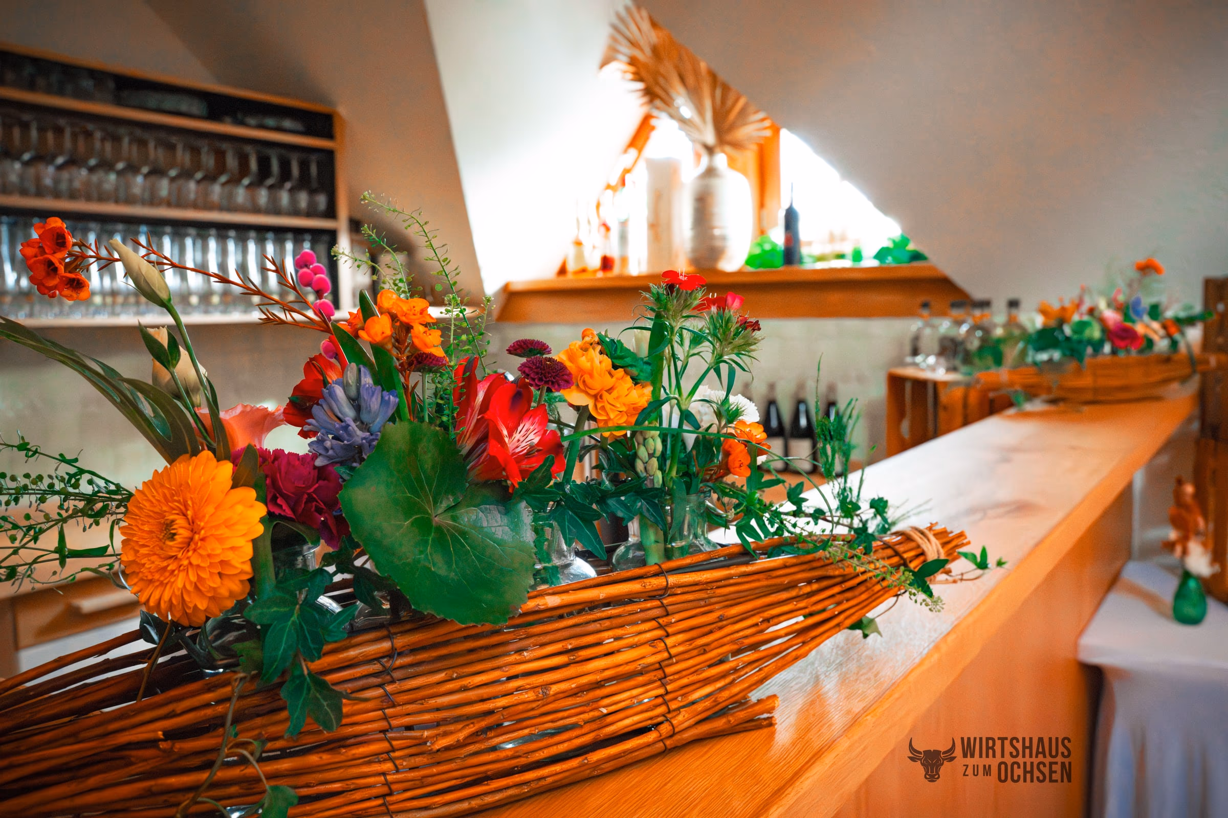 Blumen und Gläser auf der Theke im Saal
