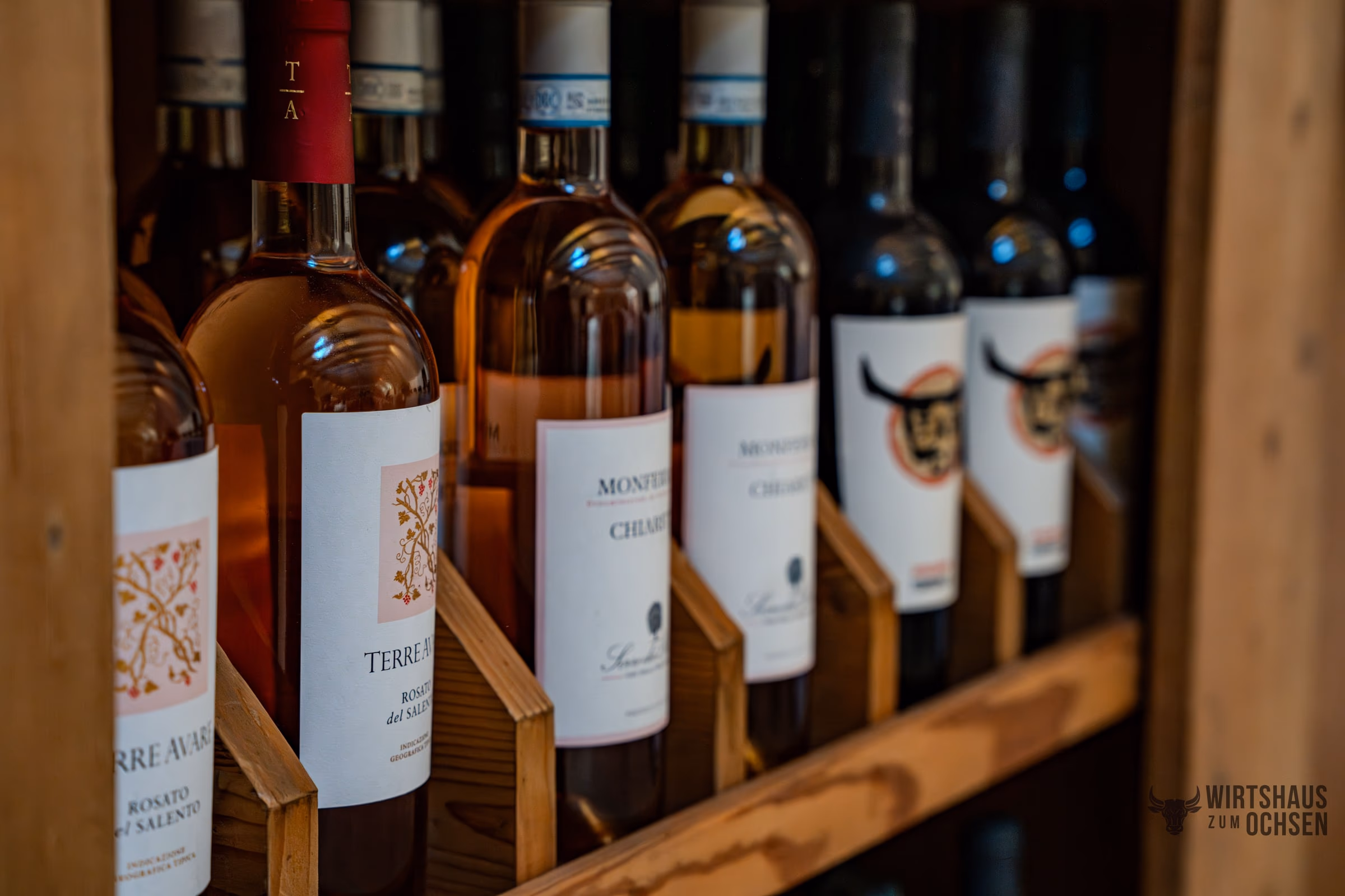 Weinregal aus Holz mit Flaschen hinter der Theke im Saal